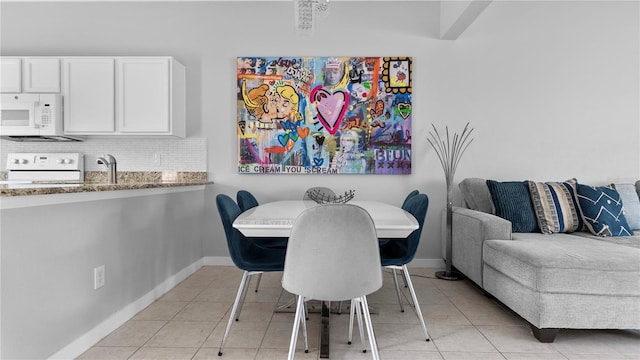 dining space featuring light tile patterned flooring and sink