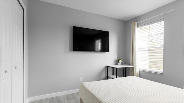 bedroom with light hardwood / wood-style flooring and a closet