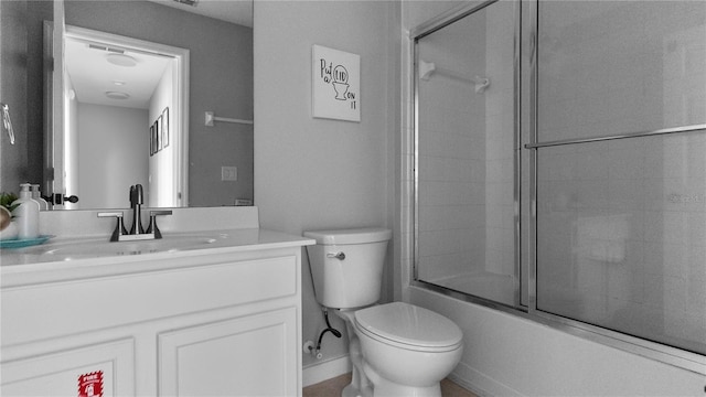 full bathroom featuring shower / bath combination with glass door, vanity, and toilet