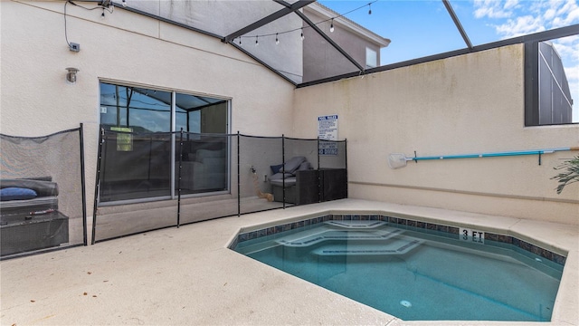 view of pool with a patio and glass enclosure