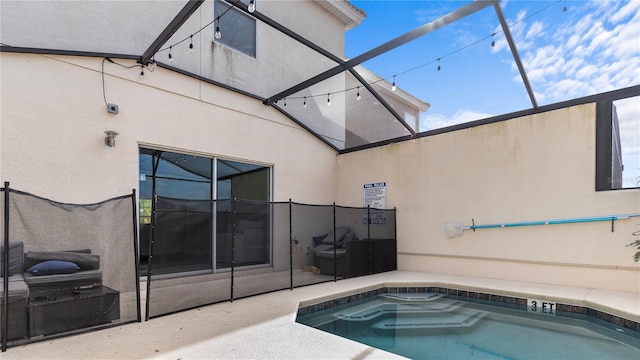 view of pool featuring glass enclosure and a patio