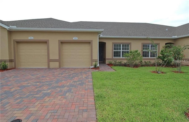 ranch-style home with a garage and a front lawn