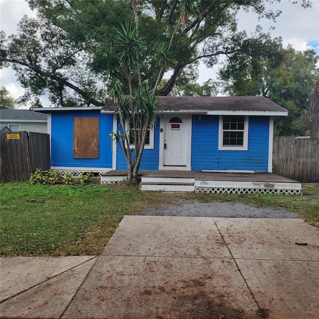 ranch-style home with a front yard and fence