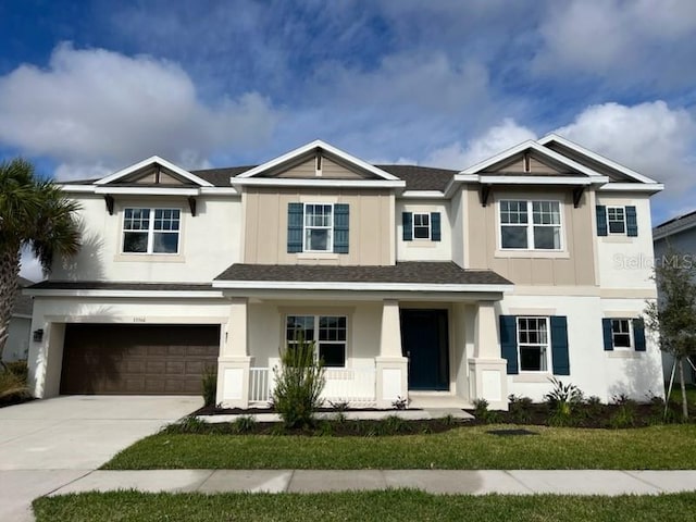 view of front of house with a porch, a garage, and a front lawn