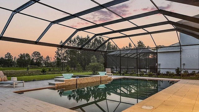 pool at dusk with a patio and glass enclosure