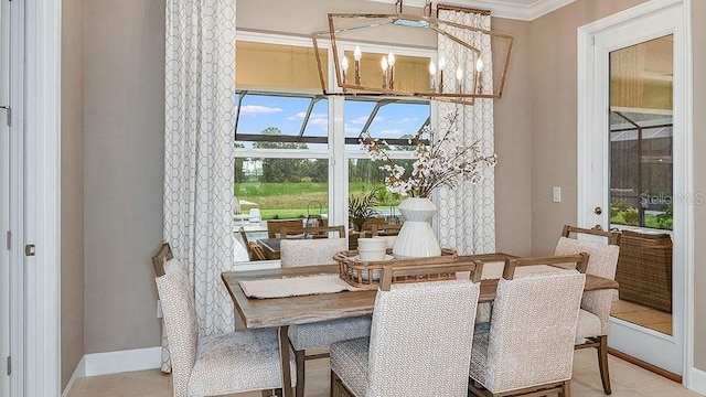 dining room featuring light tile patterned flooring, ornamental molding, and an inviting chandelier