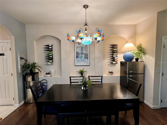 dining area with hardwood / wood-style floors and a notable chandelier