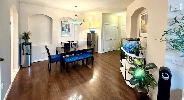 dining area featuring a notable chandelier, baseboards, and wood finished floors