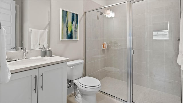 bathroom featuring vanity, toilet, and a shower with shower door