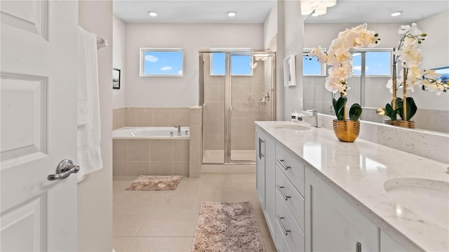 bathroom with tile patterned floors, vanity, separate shower and tub, and a wealth of natural light