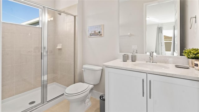 bathroom featuring tile patterned flooring, vanity, toilet, and a shower with door