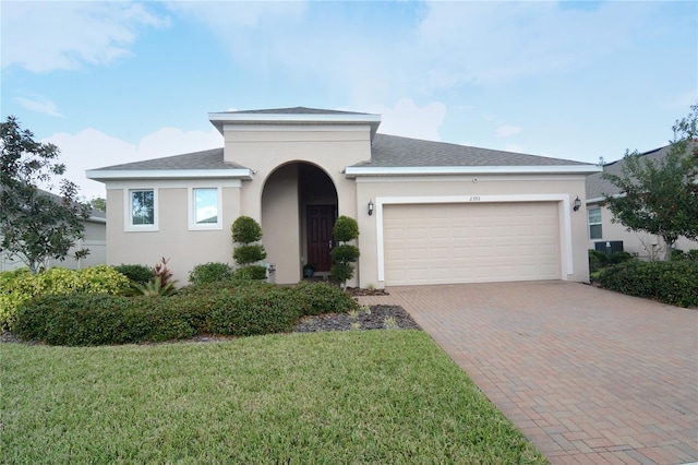 view of front of home with a garage and a front lawn