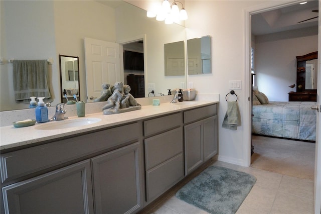 bathroom with ceiling fan with notable chandelier, vanity, and tile patterned floors