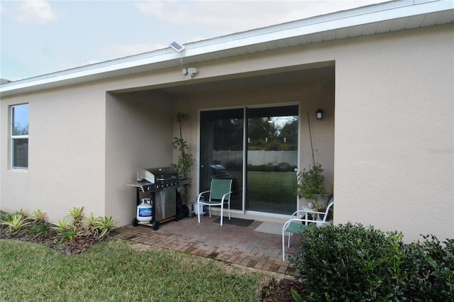 view of exterior entry featuring a patio