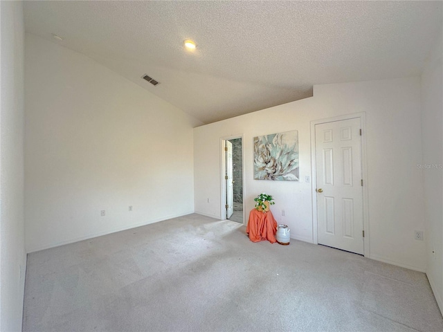 empty room featuring lofted ceiling and a textured ceiling