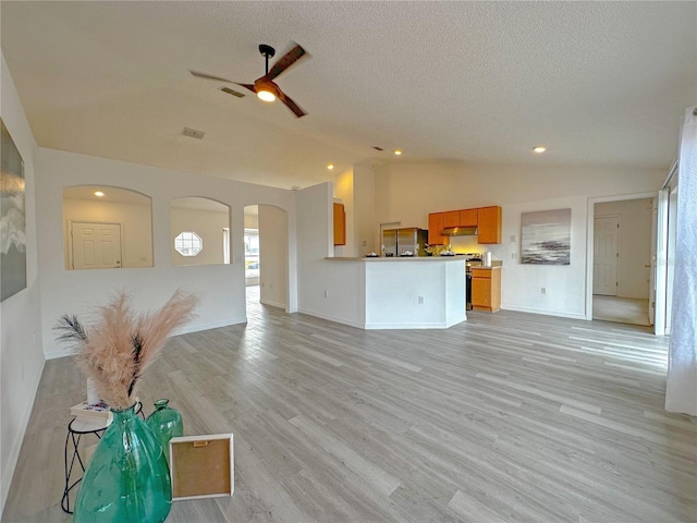 unfurnished living room featuring ceiling fan, lofted ceiling, and light hardwood / wood-style flooring