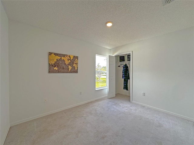 carpeted spare room featuring a textured ceiling