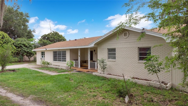 single story home featuring a porch and a front lawn