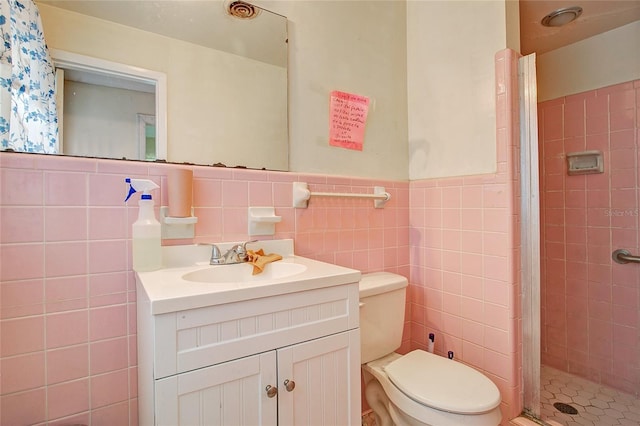 bathroom with vanity, tile walls, and a shower with shower door