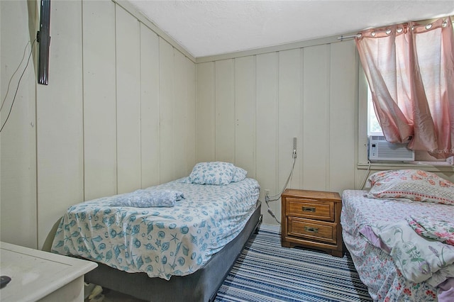 bedroom featuring wood walls and cooling unit