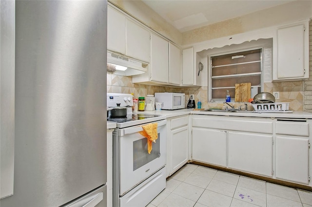 kitchen featuring tasteful backsplash, white cabinets, and white appliances