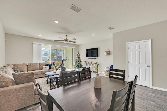 dining room featuring a textured ceiling, ceiling fan, and light wood-type flooring