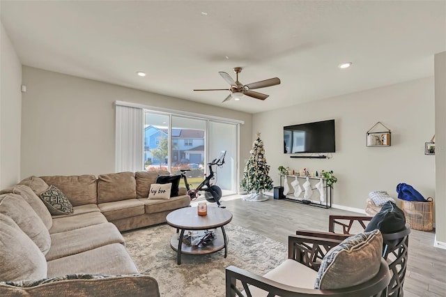 living room featuring ceiling fan and light hardwood / wood-style floors