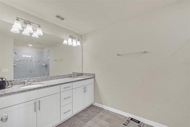 bathroom with hardwood / wood-style flooring, vanity, and a shower with door