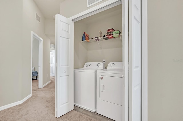 laundry area with light colored carpet and washing machine and dryer