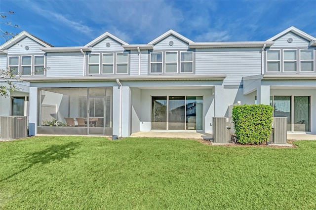 rear view of house featuring a sunroom, a yard, and cooling unit