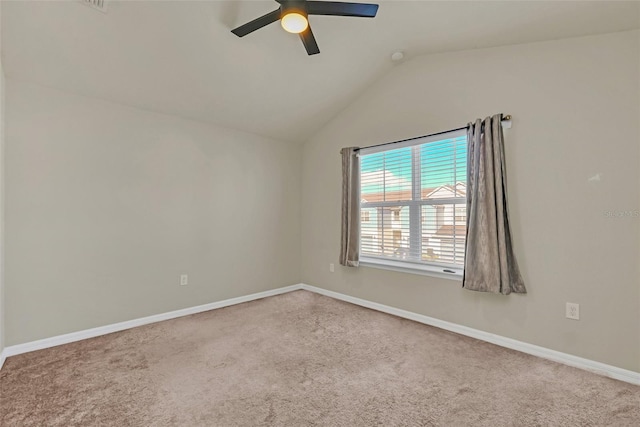 spare room featuring lofted ceiling, carpet, and ceiling fan