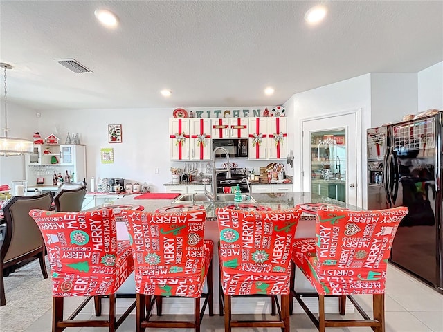 dining space with sink, light tile patterned flooring, and a textured ceiling