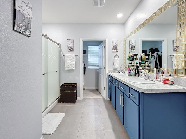 bathroom featuring tile patterned flooring, vanity, and walk in shower