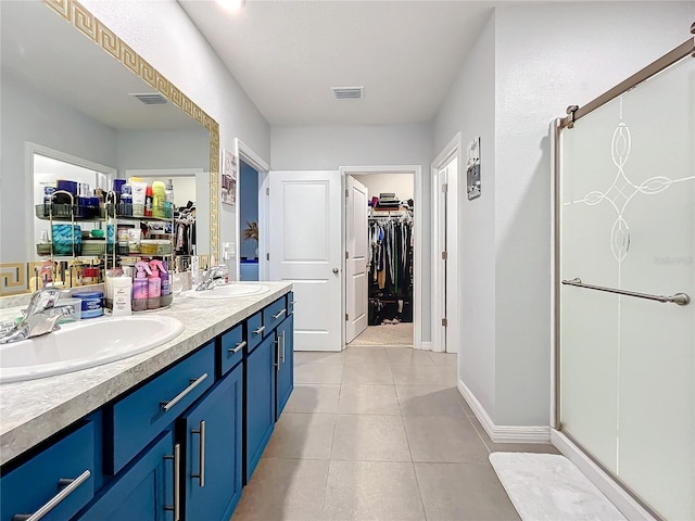 bathroom with tile patterned flooring, vanity, and a shower with door