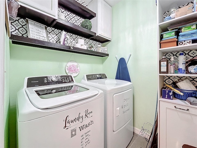 laundry area featuring washing machine and clothes dryer and cabinets