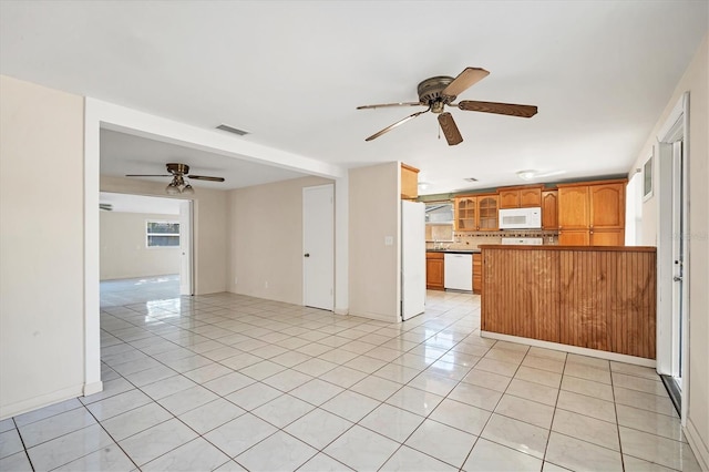 kitchen featuring ceiling fan, kitchen peninsula, white appliances, decorative backsplash, and light tile patterned floors