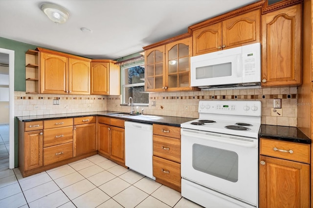 kitchen with tasteful backsplash, sink, light tile patterned flooring, and white appliances