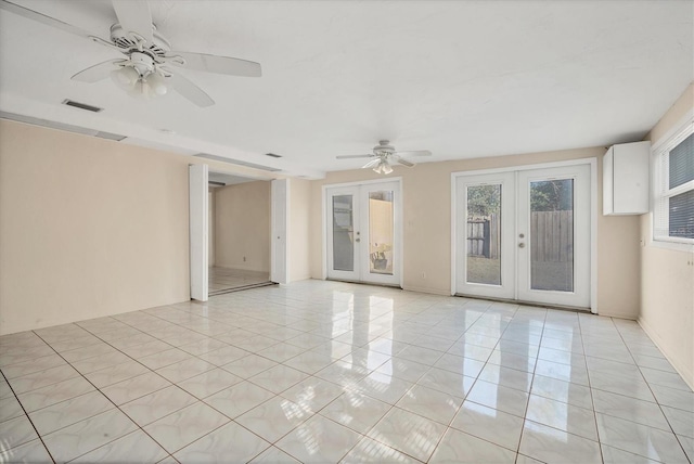 empty room with french doors, ceiling fan, and light tile patterned flooring