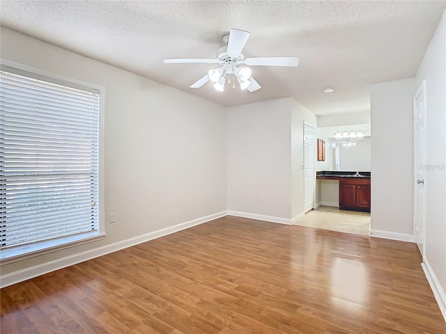 spare room featuring ceiling fan, light hardwood / wood-style flooring, a textured ceiling, and sink