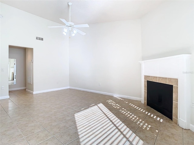 unfurnished living room featuring ceiling fan, light tile patterned flooring, a fireplace, and high vaulted ceiling