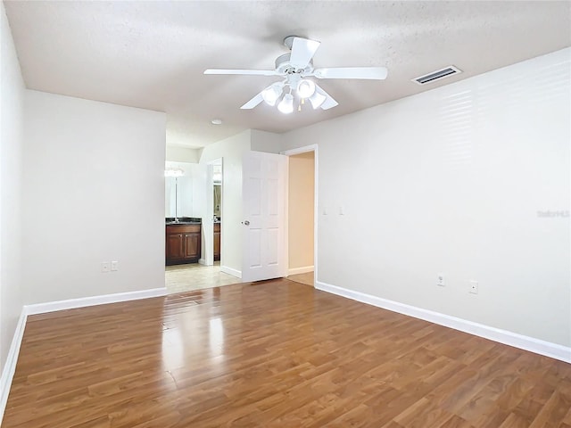 spare room with wood-type flooring, a textured ceiling, and ceiling fan