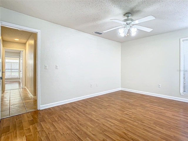 spare room featuring ceiling fan, a textured ceiling, and hardwood / wood-style flooring