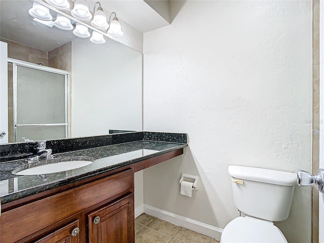 bathroom with tile patterned flooring, vanity, toilet, and an enclosed shower