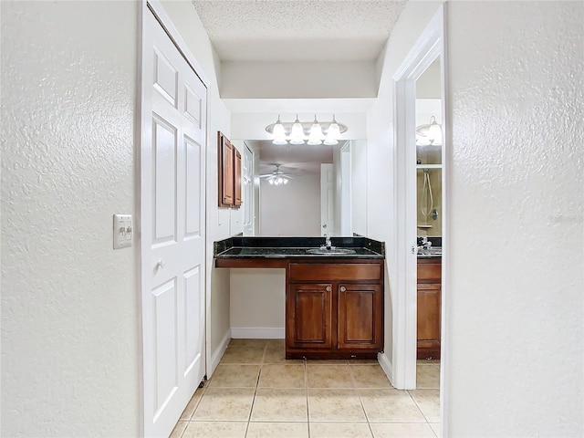 bathroom with vanity, tile patterned flooring, ceiling fan, a textured ceiling, and a shower with shower door