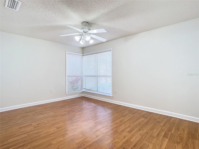 spare room with a textured ceiling, hardwood / wood-style flooring, and ceiling fan