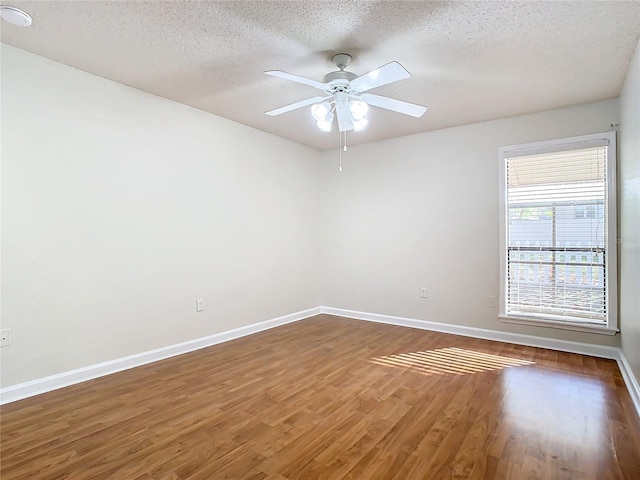 empty room with a textured ceiling, dark hardwood / wood-style floors, and ceiling fan