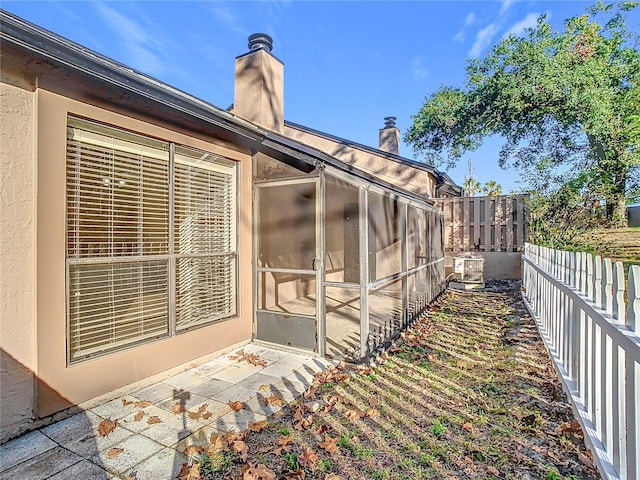 view of side of property with central air condition unit and a sunroom