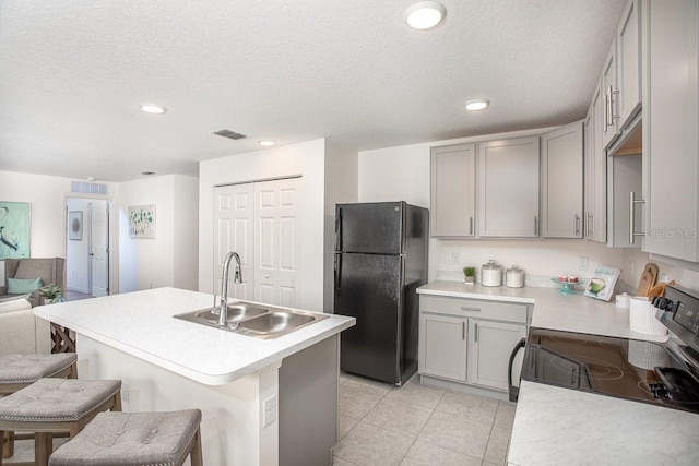 kitchen featuring black refrigerator, sink, electric range, gray cabinets, and light tile patterned floors