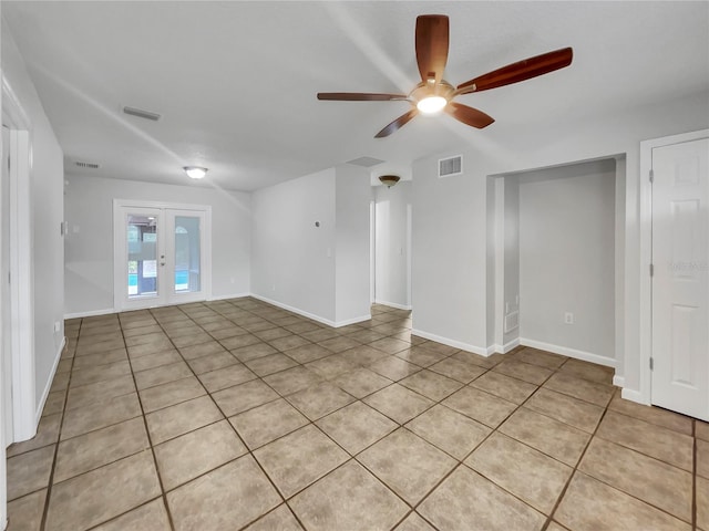 empty room featuring ceiling fan, french doors, and light tile patterned flooring