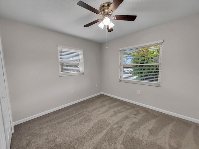 spare room with carpet flooring, ceiling fan, and a wealth of natural light